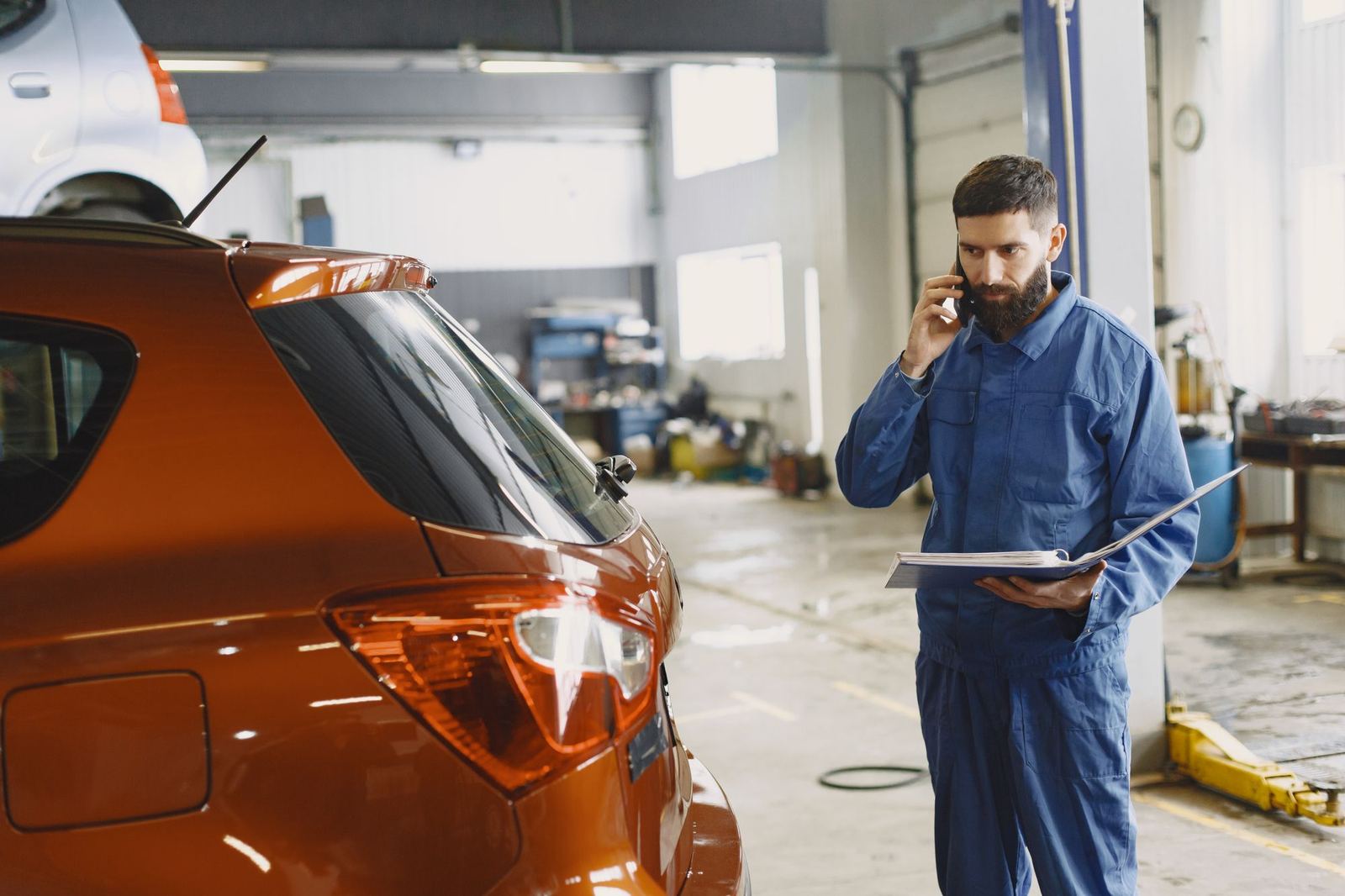 A service technician taking a customer call in the service bay