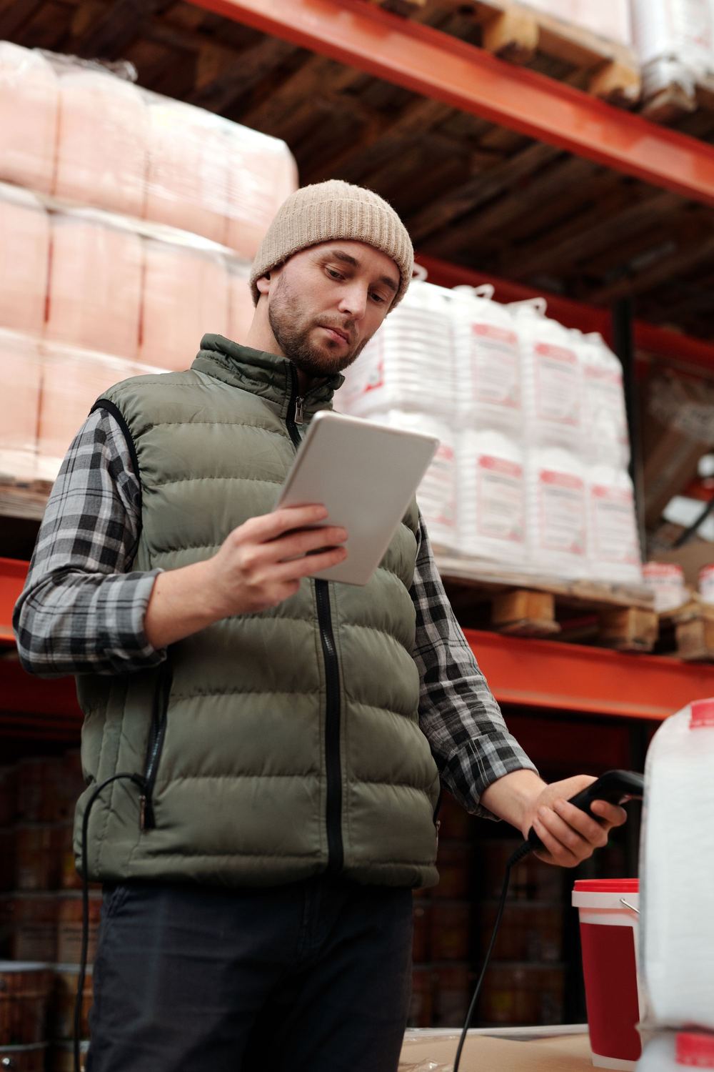 A warehouse team member checking stock levels on a tablet